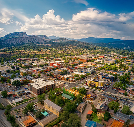 Aerial view of scenic mountain town with commercial buildings residential neighborhoods
